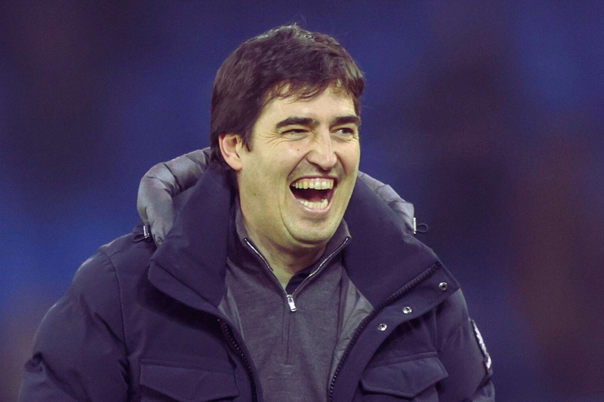 Bournemouth manager Andoni Iraola wearing a dark winter jacket, appearing in high spirits during a match.